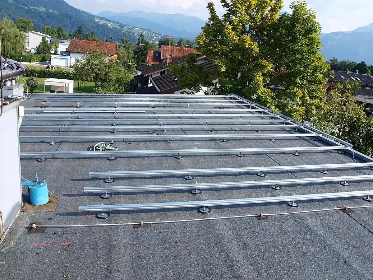 Aluminum mounting rails fastened across a flat roof, ready for solar panels.