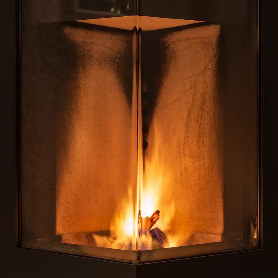 Flames burning behind the glass door of a wood stove.