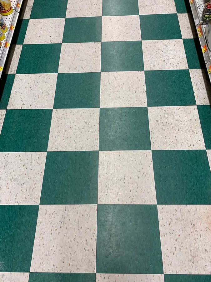A floor of green and white checkered vinyl tile.