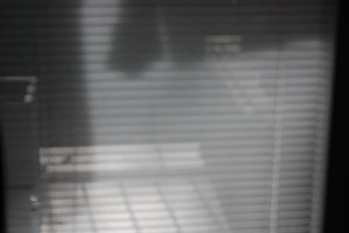 A translucent white roller blind in front of a window, softening the daylight.